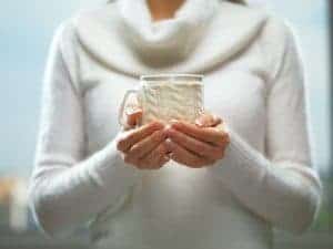 La mujer sostiene una taza de café de invierno